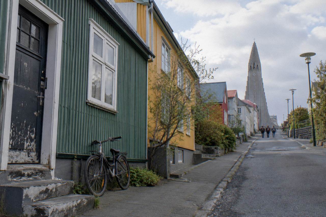 Colourful corrugated iron buildings on a quiet Reykjavik street with a church tower in the background