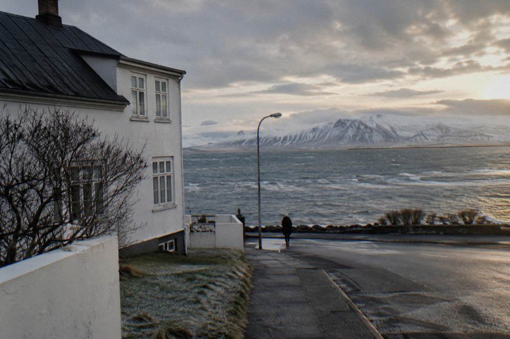 Quiet Reykjavik street in low winter light with mountains across the water