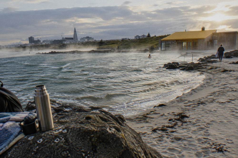 Open air geothermal pool in Reykjavik with steam rising over calm water