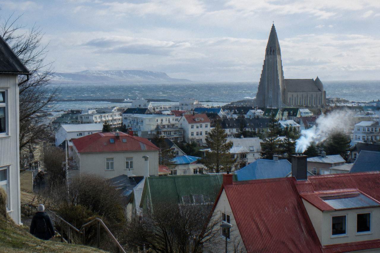 Colourful corrugated iron houses on a quiet street in central Reykjavik with the Hallgrimskirkja tower behind them