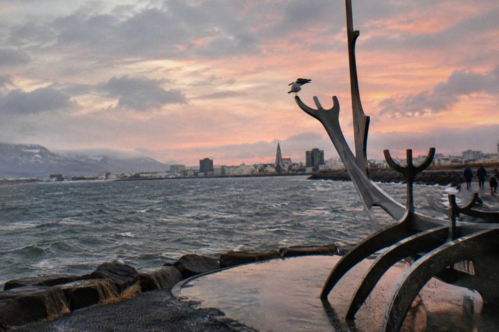 Sculpture of a Viking ship silhouette on the waterfront promenade at dusk