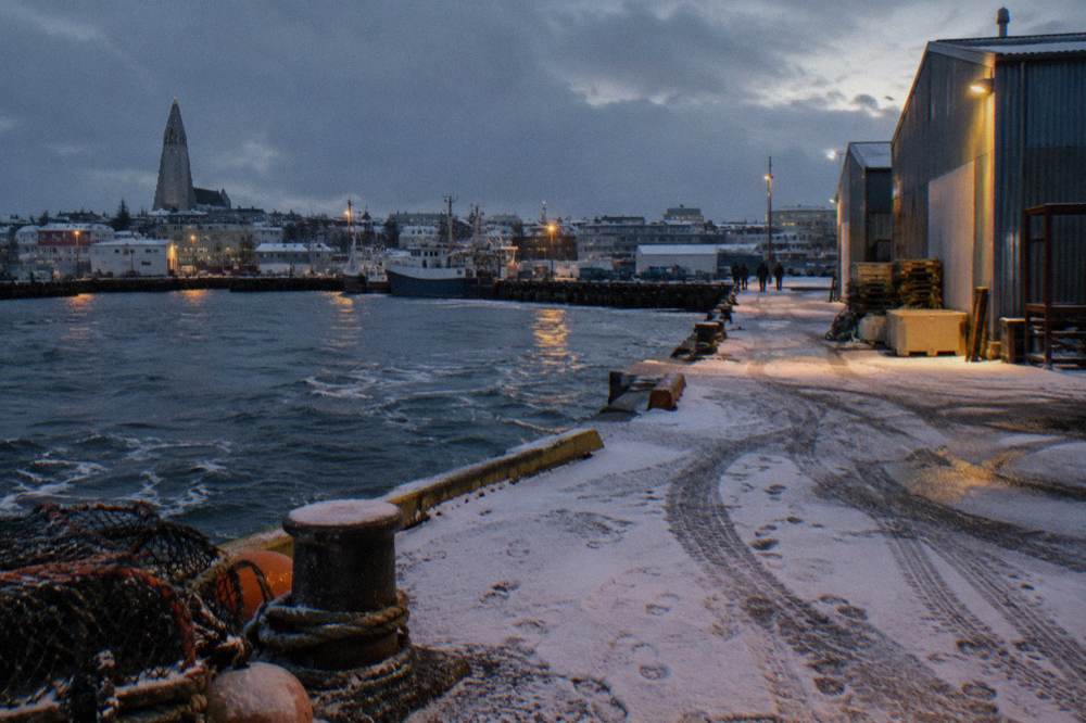 Snow-dusted street corner in central Reykjavik under streetlights
