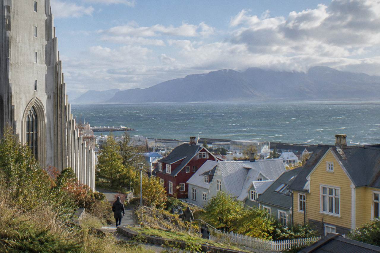 Colourful corrugated iron houses on a quiet Reykjavik street with mountains behind