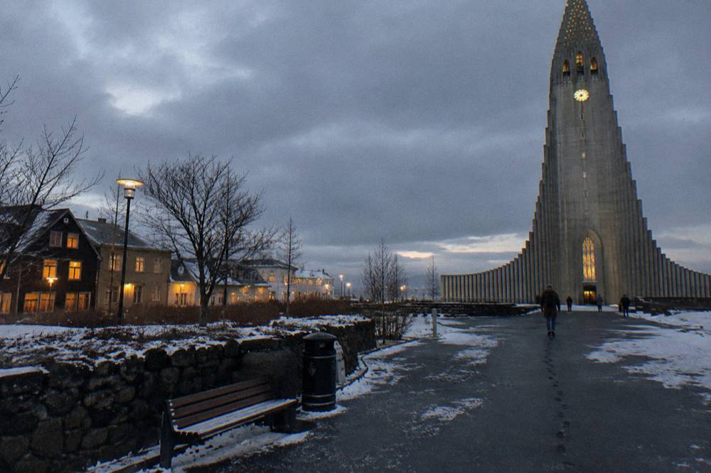 Dark winter street in Reykjavik with snow on the pavement and glowing windows
