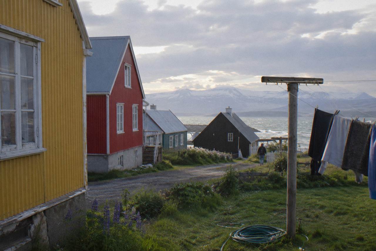 Colourful corrugated iron houses on a quiet Reykjavik street with distant mountains