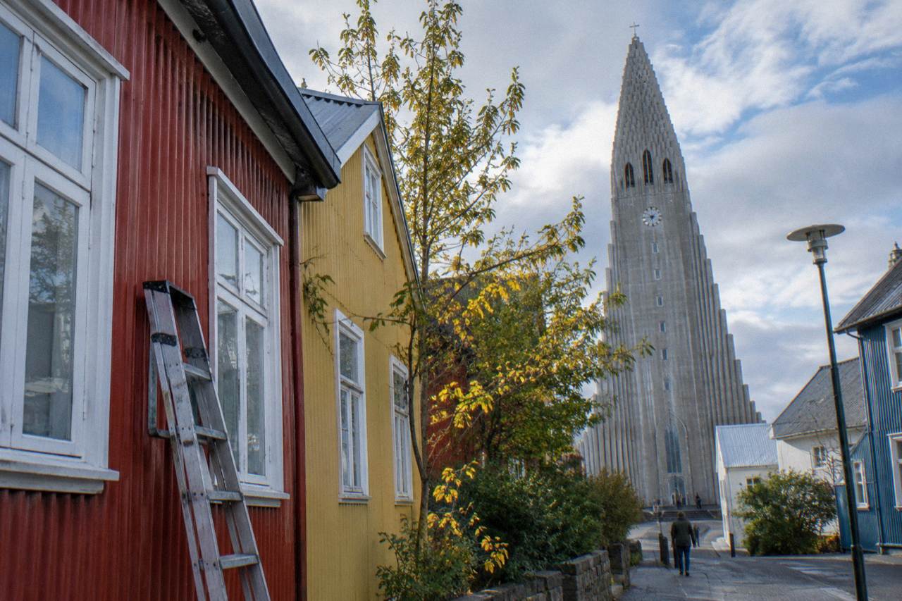 Colourful corrugated iron houses in central Reykjavik with a church tower rising behind them