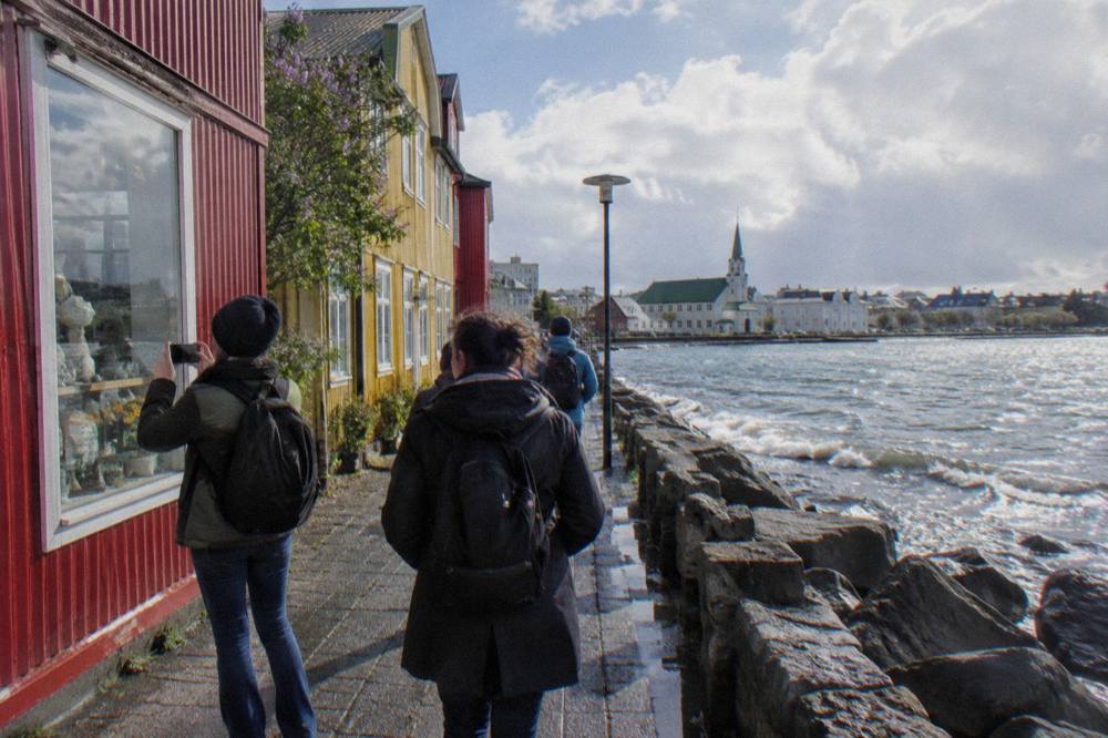 A guide leading a small group along a colourful Reykjavik street between food stops