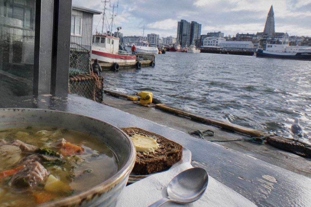 A bowl of Icelandic lamb soup and rye bread on a cafe counter