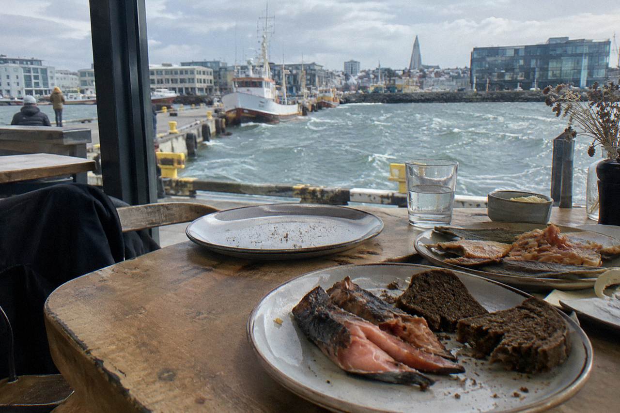 Plates of Icelandic seafood and rye bread on a wooden table in a Reykjavik restaurant