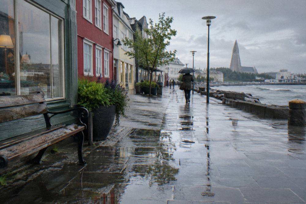 Rain-washed pedestrian street in central Reykjavik lined with shopfronts