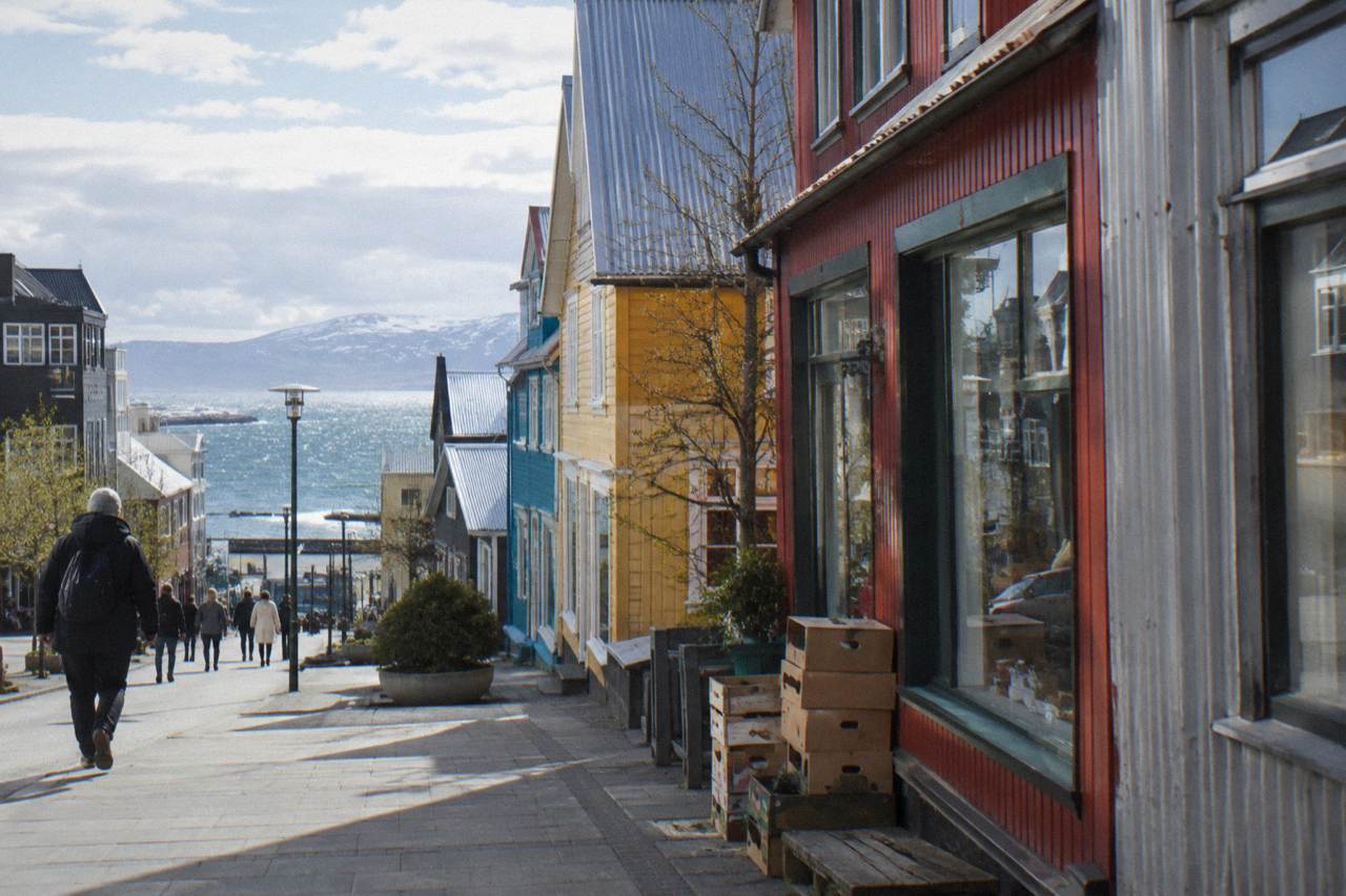 Colourful low storefronts along a pedestrian shopping street in Reykjavik on a bright day