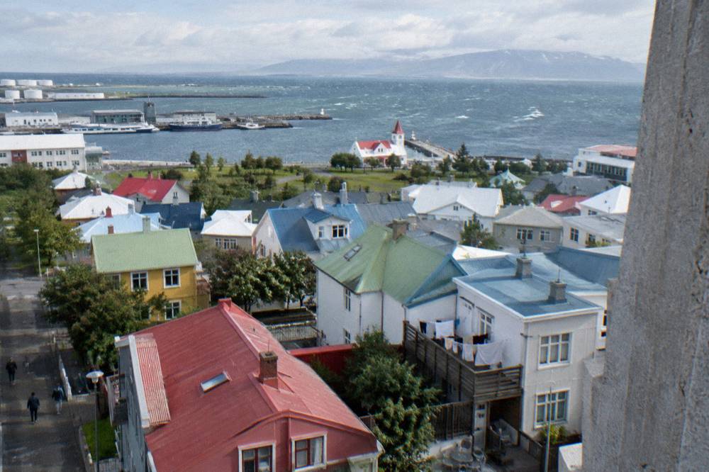Colourful rooftops of central Reykjavik seen from a high vantage point with the harbour beyond