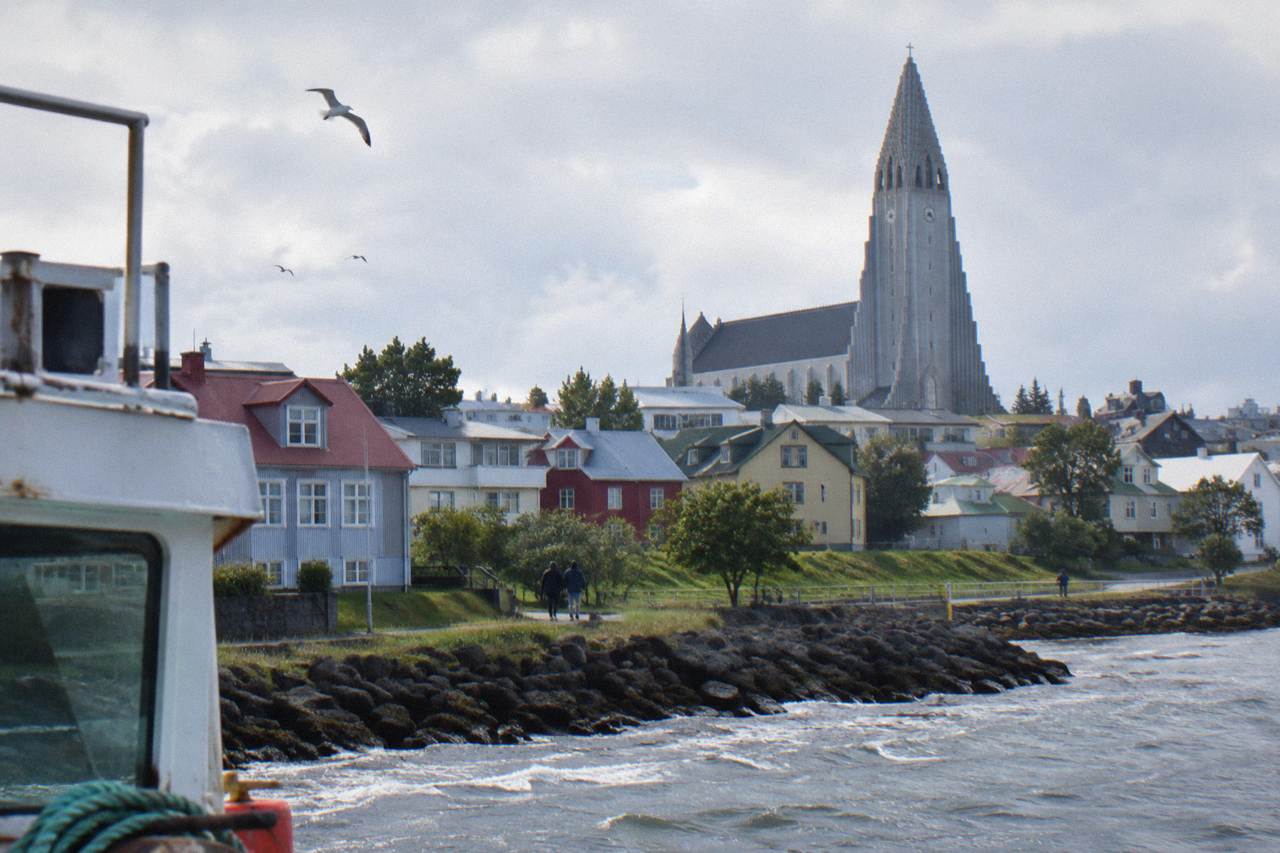 Hallgrímskirkja church rising above rooftops in central Reykjavik under a pale sky