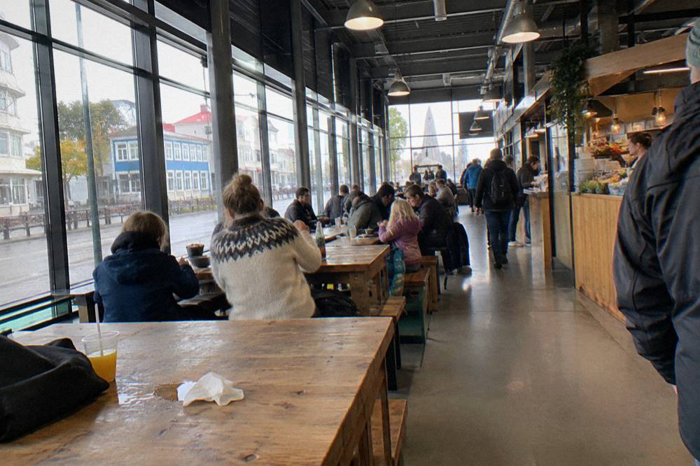 Food hall counters and communal tables inside a converted bus terminal