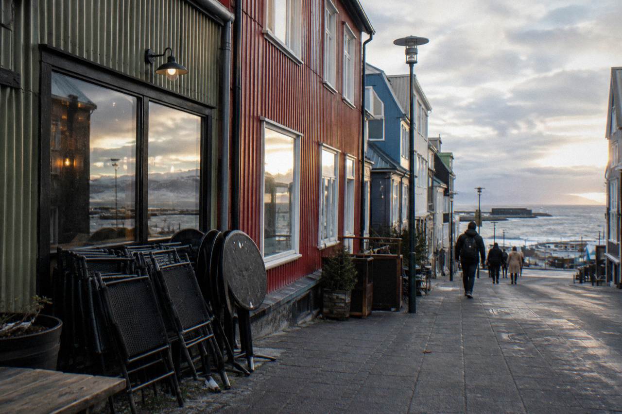 Warm evening light on the closed terraces and bar fronts of a pedestrian street in central Reykjavik