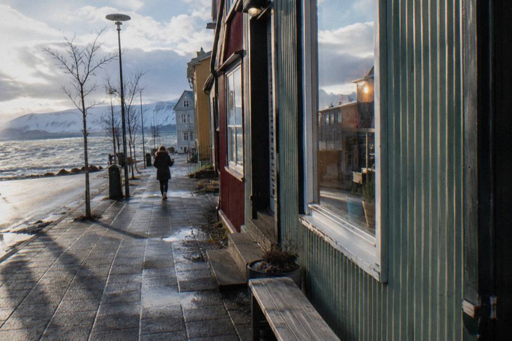 Reykjavik main street with low morning sun on shopfronts and few pedestrians