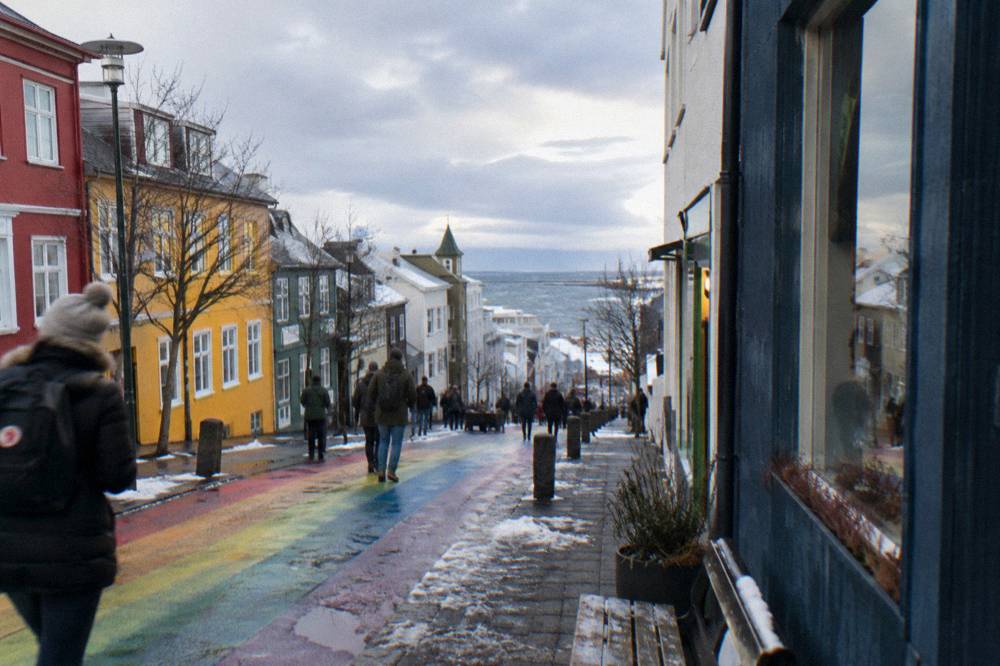 Busy pedestrian street in central Reykjavik with walkers between colored storefronts