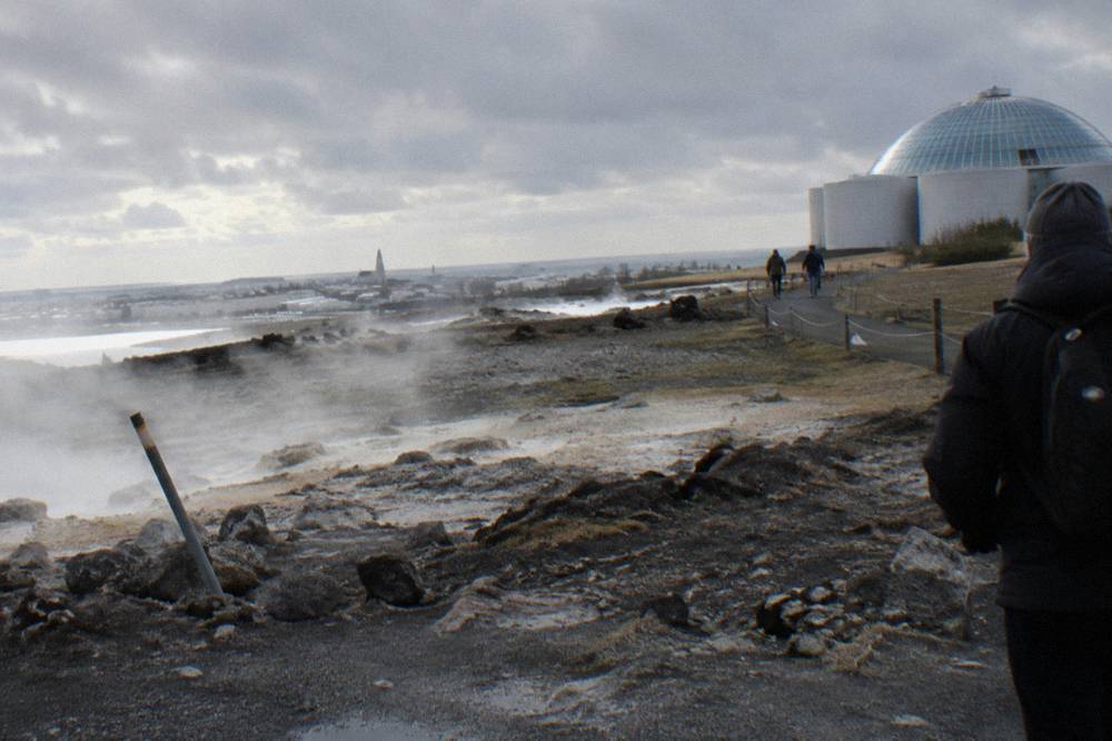 Golden Circle geothermal field with steaming vents and a flat white plain under grey sky