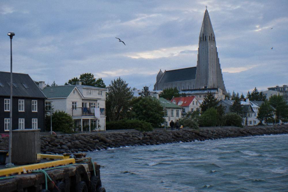 Hallgrimskirkja church tower rising above low city rooftops in soft light