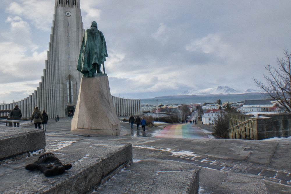 Leifur Eiriksson statue in front of Hallgrimskirkja with the rainbow street descending behind