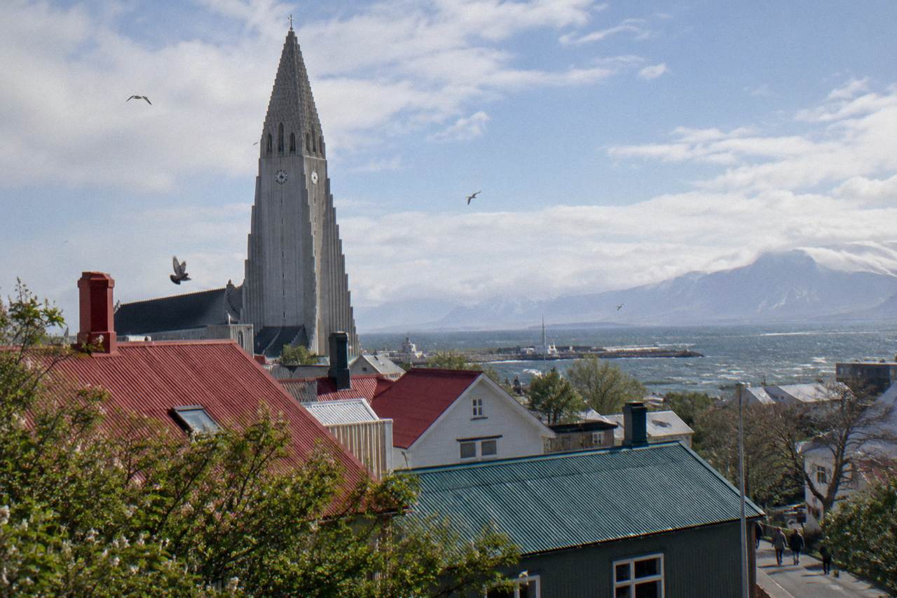 The stepped concrete tower of Hallgrimskirkja rising above rooftops on a bright morning