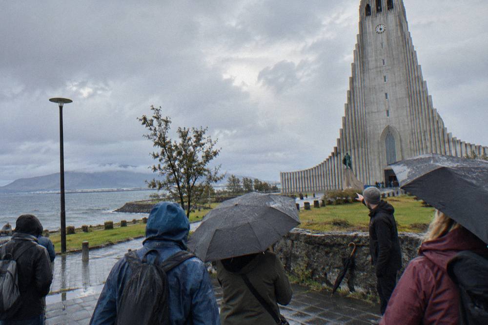 A guide speaking to a small group beside a stone building in central Reykjavik