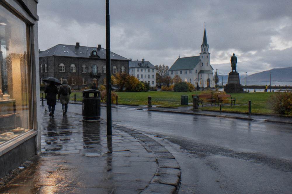 Rain jackets and umbrellas on a windy street corner in Reykjavik