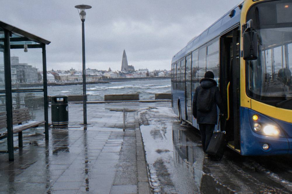 A blue Straeto city bus at a stop on a Reykjavik street