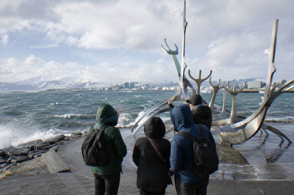 A guide speaking with a small group beside the sculpture Sun Voyager on Reykjavik waterfront