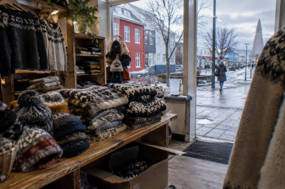 Icelandic wool hats and mittens displayed in a warmly lit Reykjavik gift shop during winter