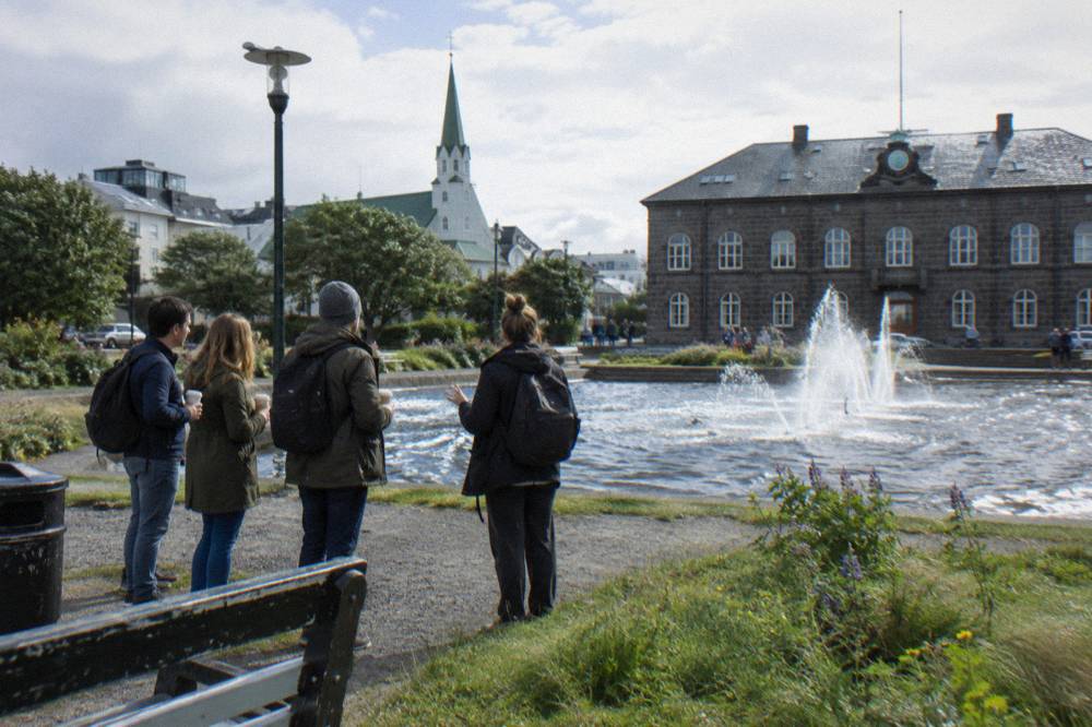 A local guide speaking to a small group of visitors on a pedestrian street in central Reykjavik