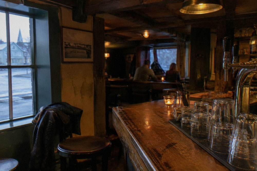 Cozy bar interior in Reykjavik with wooden counters and low lighting