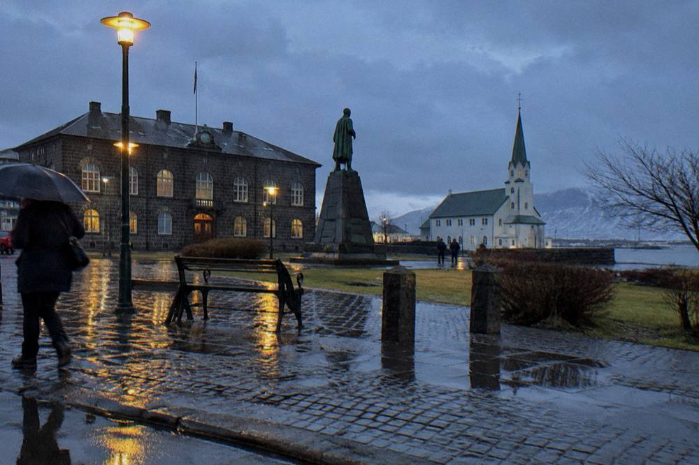 Wet cobblestone street in Reykjavik at night reflecting streetlights after rain
