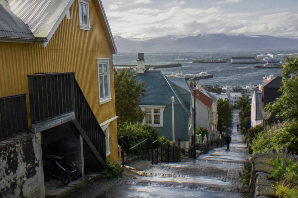 View from the upper deck of a sightseeing bus looking down a Reykjavik street lined with corrugated iron houses