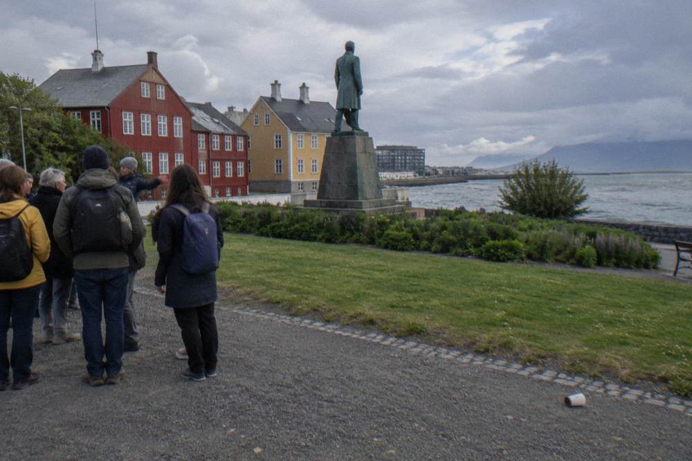 A small group of walkers gathered around a guide on a painted street in central Reykjavik