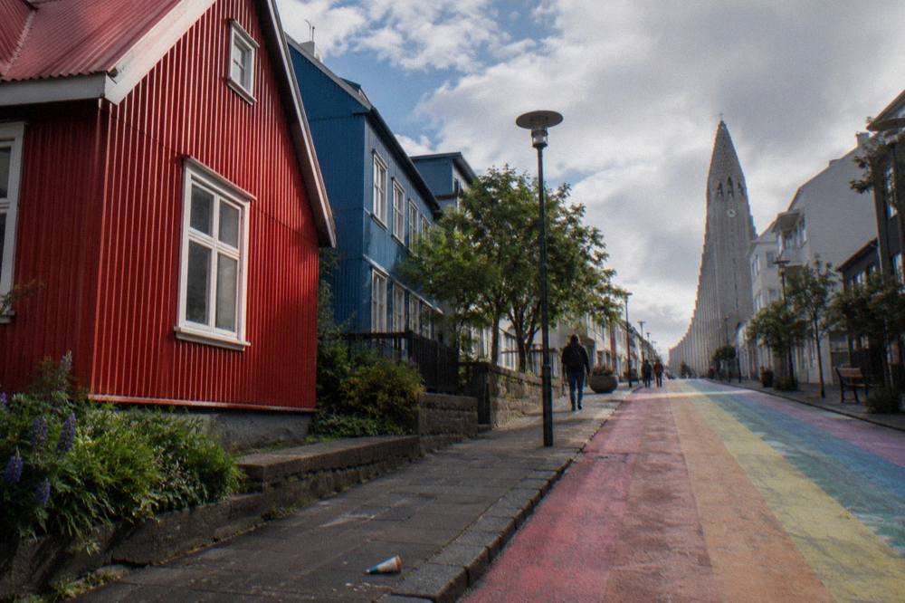 Colourful corrugated iron houses on a steep Reykjavik street with the church tower above
