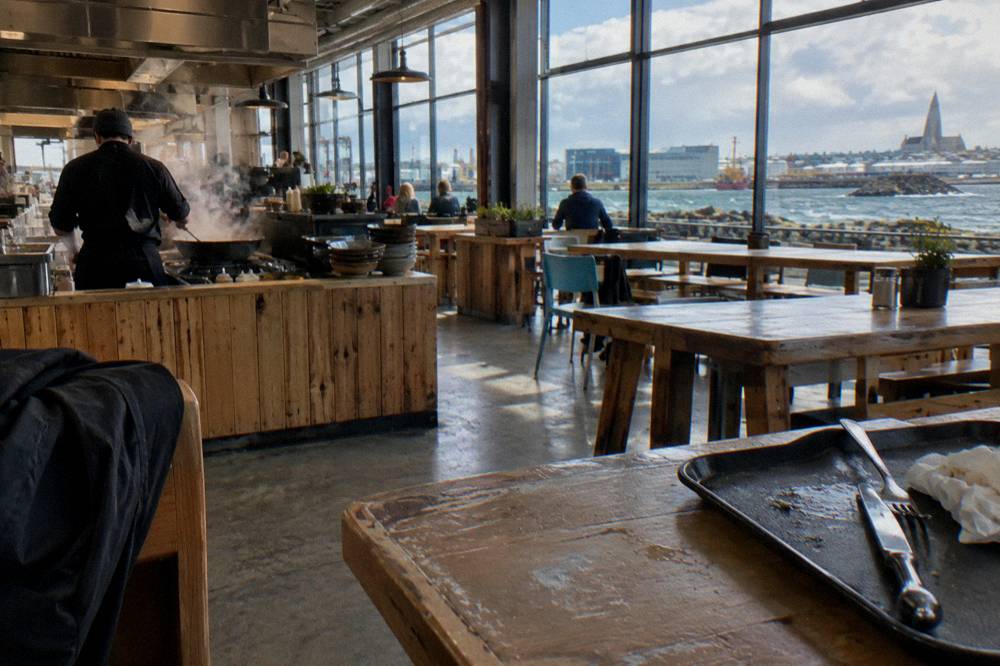 Food hall interior with counter vendors and communal tables in a converted bus station