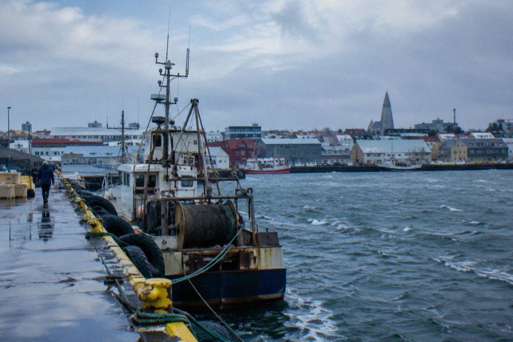Harbour pier in Reykjavik with a docked vessel and distant city rooftops