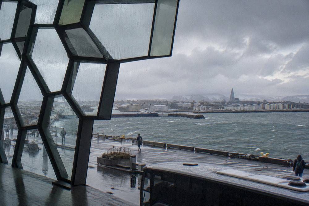 Tour bus parked near the Harpa concert hall on a wet overcast afternoon in Reykjavik