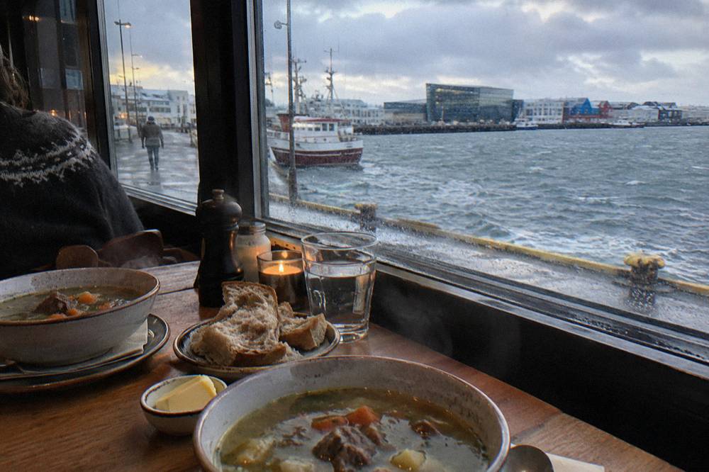 Icelandic lamb soup and fresh bread on a restaurant table in warm light