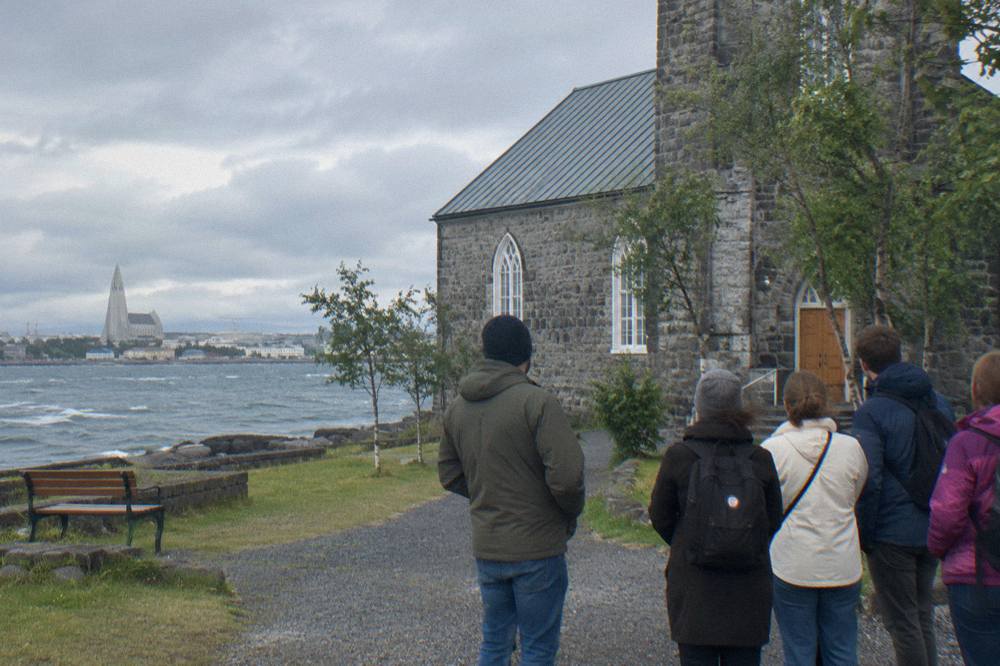 A local guide speaking to a small group of visitors on a Reykjavik street corner