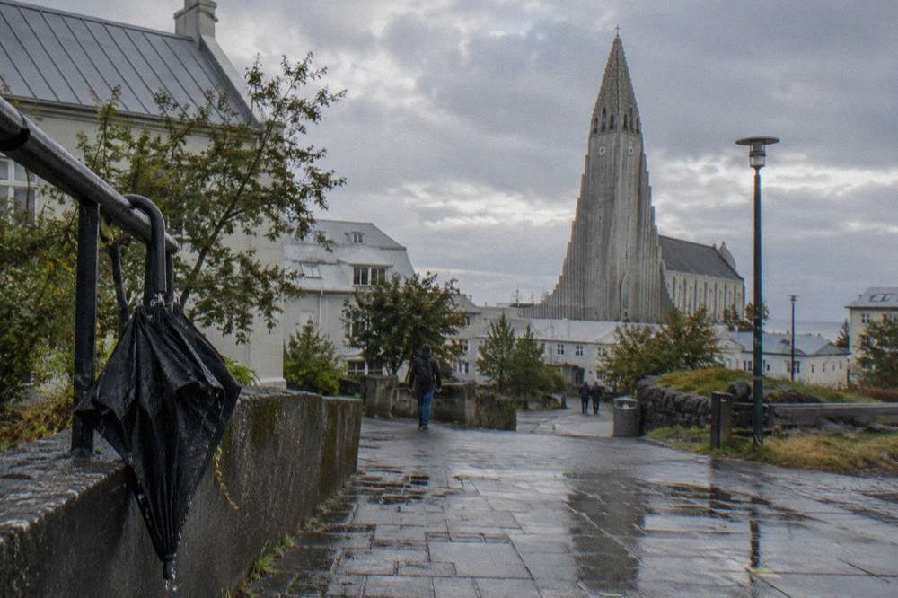 The stepped concrete tower of Hallgrimskirkja church rising above rooftops under a grey sky