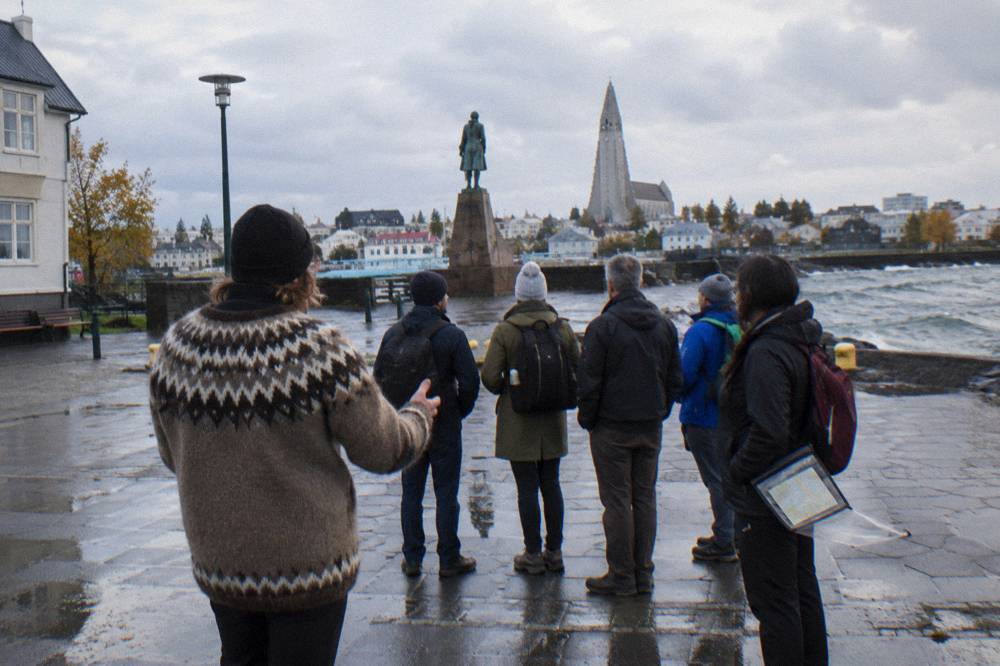 A guide speaking to a small group of visitors on a pedestrian street in central Reykjavik