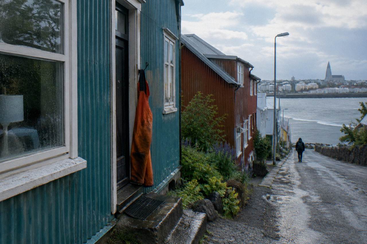 Colourful corrugated iron houses on a quiet Reykjavik street with a church tower in the distance