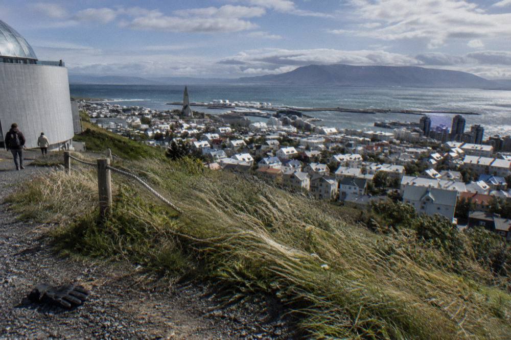 View down a sloping central Reykjavik street toward the harbour and distant mountains
