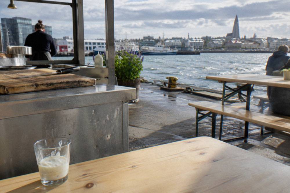 Food stalls and shared tables inside a bright Reykjavik food hall
