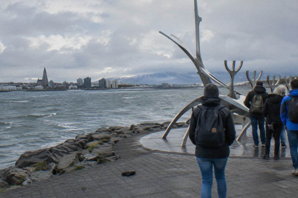 A walking tour group gathered near the Sun Voyager sculpture on the waterfront path