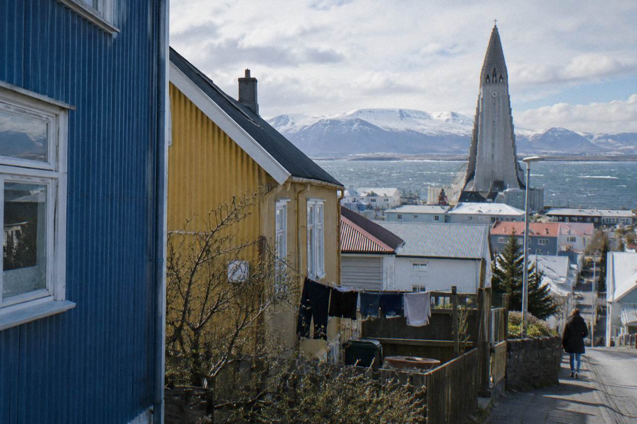 Colourful corrugated iron houses on a quiet Reykjavik street with mountains in the distance
